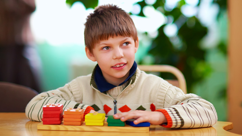 Photo of young boy working on a block puzzle.